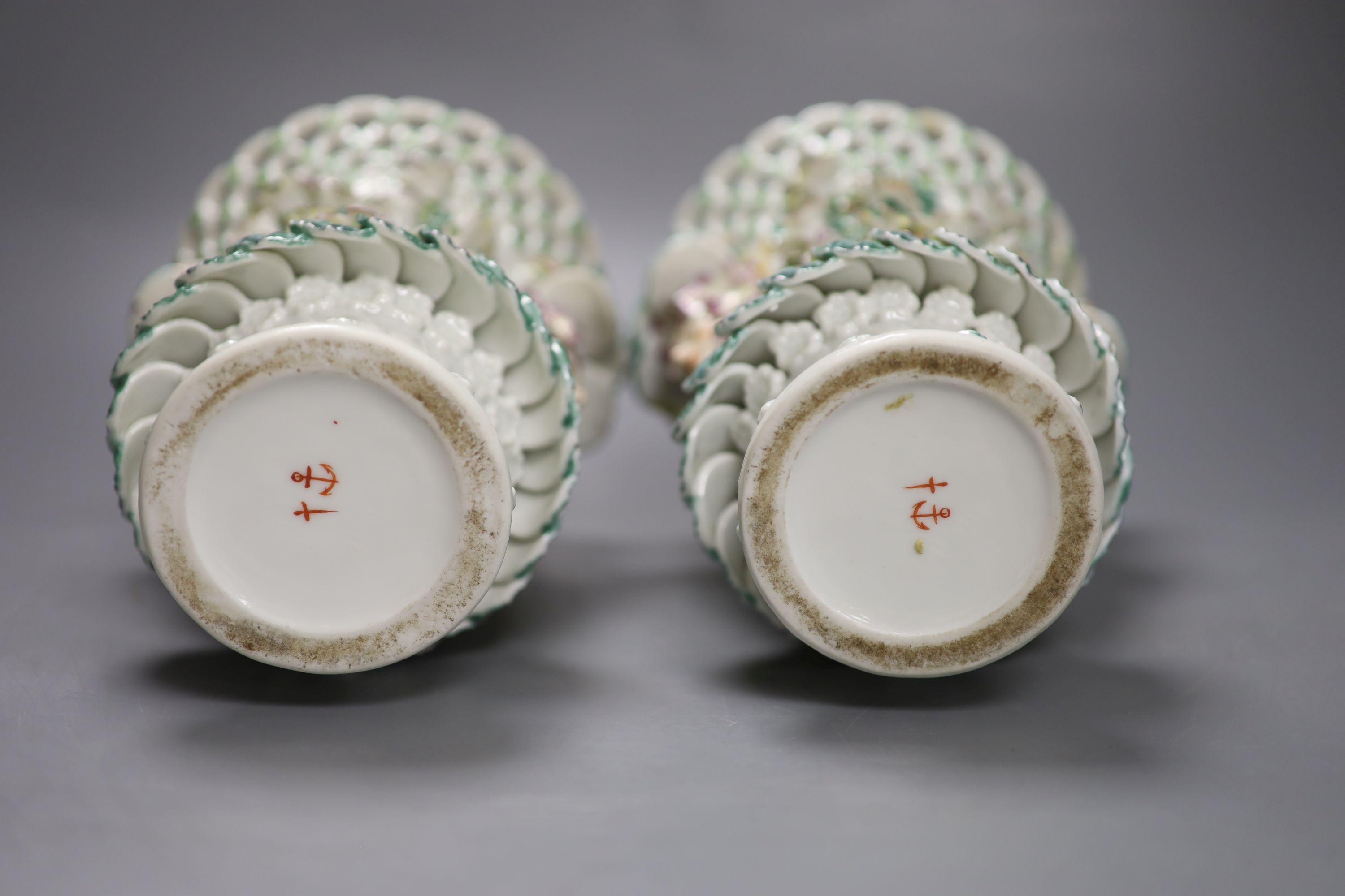 A pair of Continental frill vases with pierced necks and applied mask heads encrusted with flowers, height 18cm